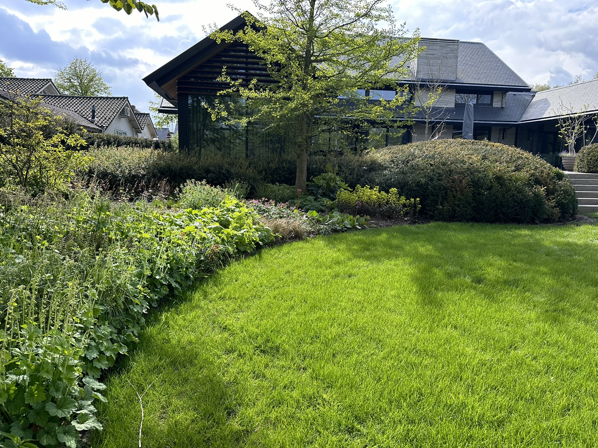 Natuurlijke tuin met bloemenborders, bomen en zichtlijnen
